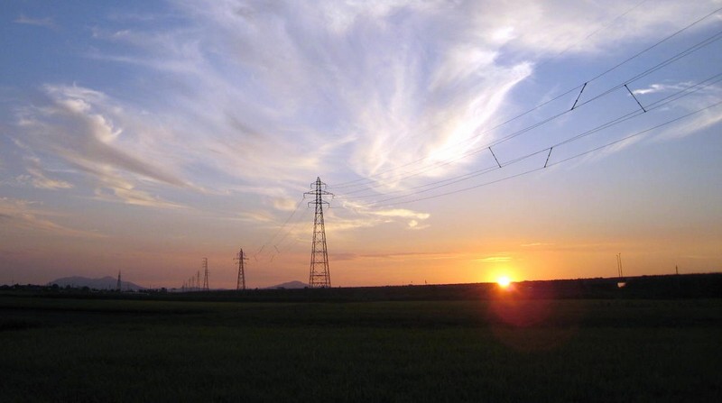 高圧送電線のイメージ（夕日と送電鉄塔）